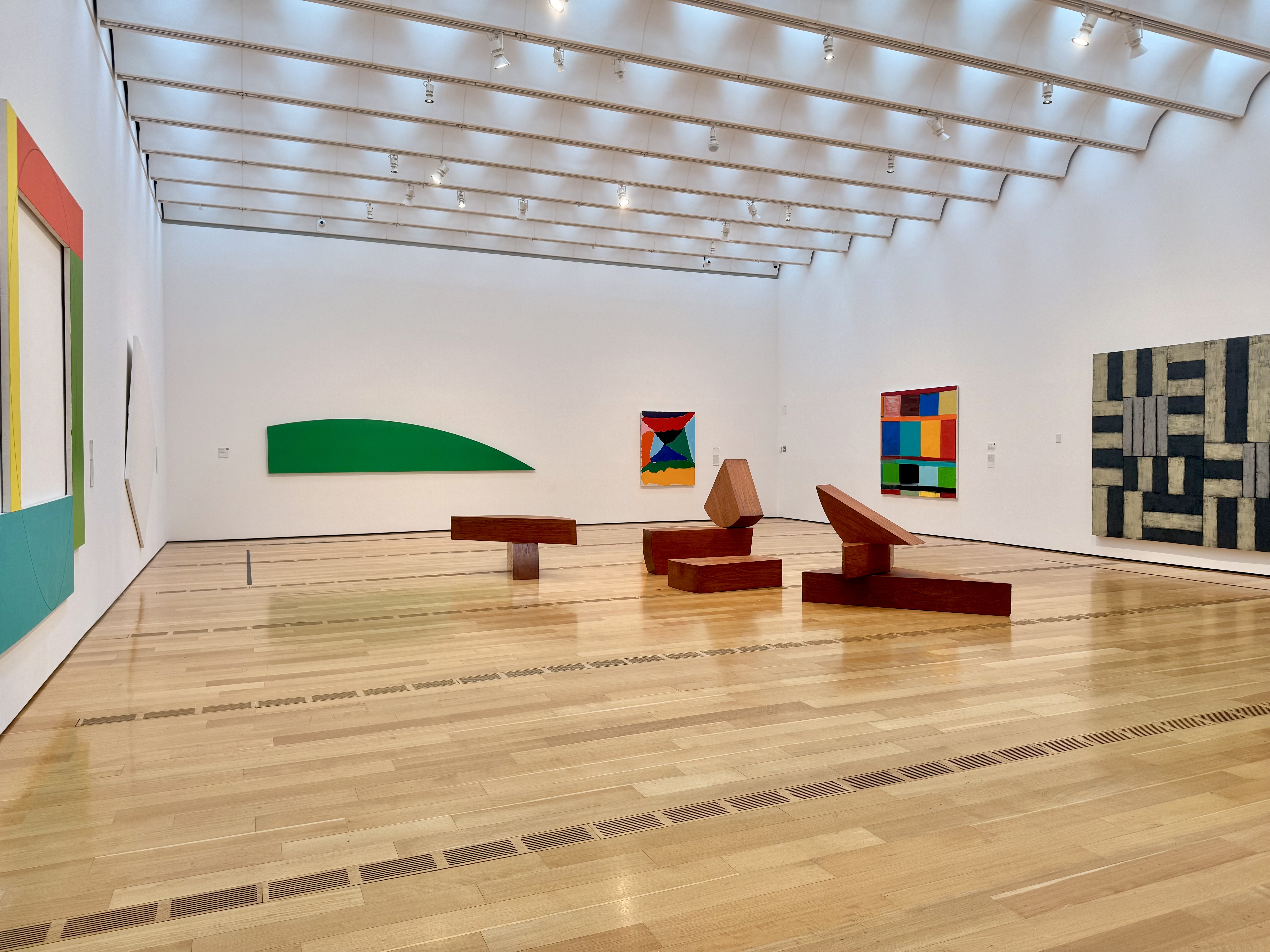a photo of a gallery room with one giant painting per wall