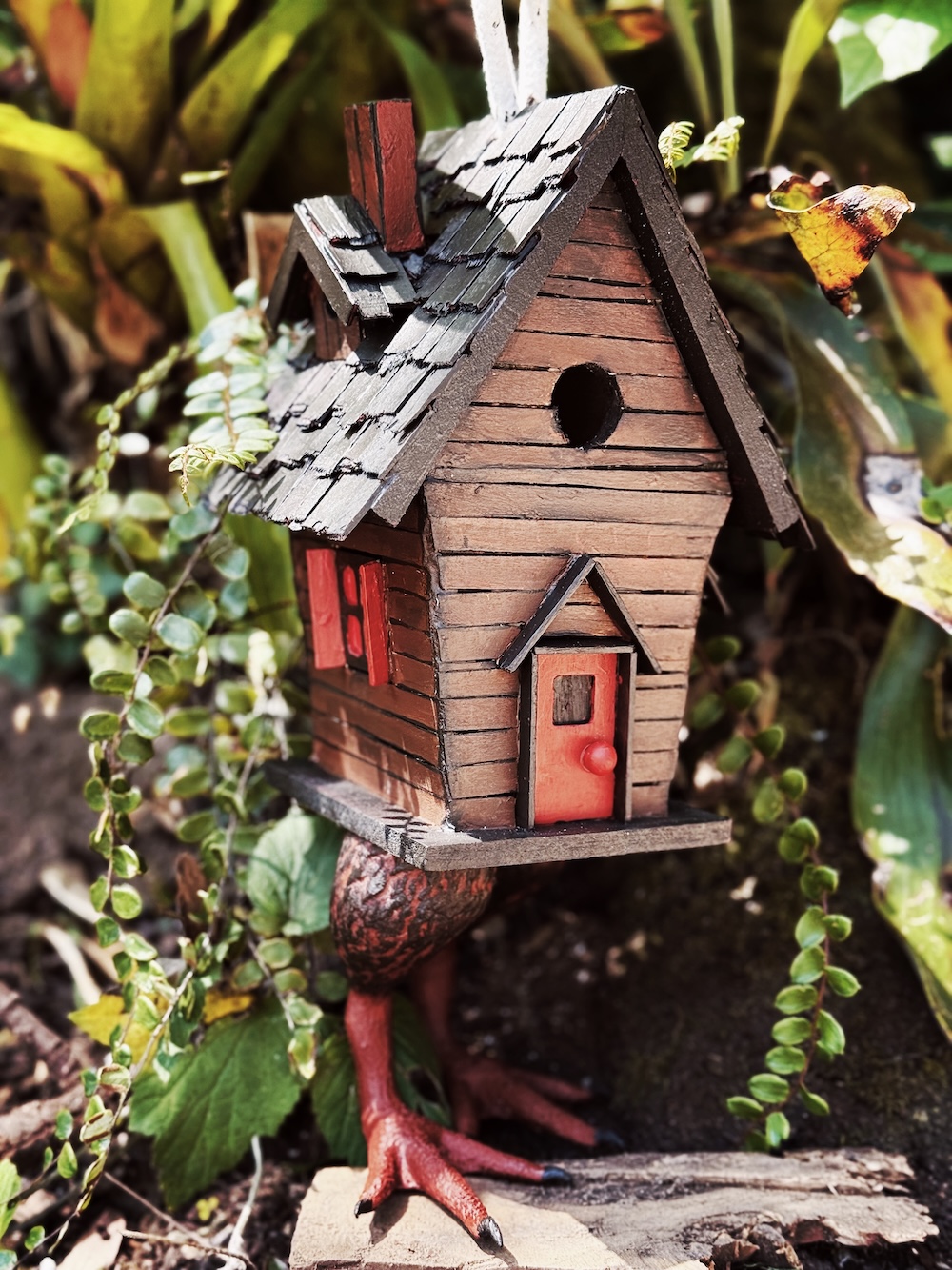 front side of a popsicle sticks hut on chicken legs
